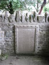 A rectangular stone-carved memorial with a carved embellishment and records the 13 men of Horrington. who fell in WW1.