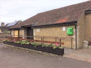 A low, modern build with access ramp and flower baskets lining the entry at Dinder.