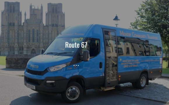 A very shiny, royal blue minibus type vehicle in front of the Cathedral by Brown's Gate.